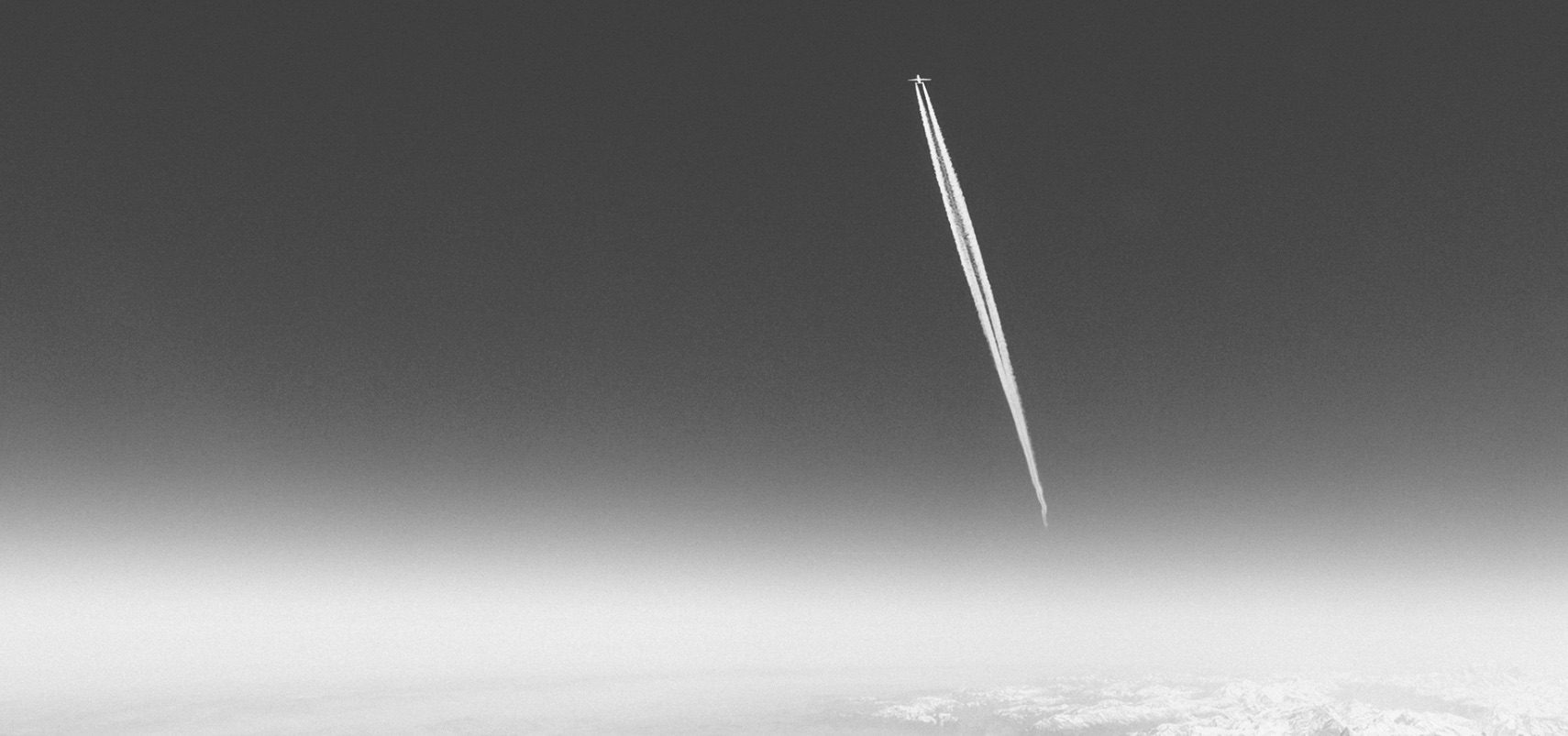 Photograph of airplane and contrail far up in the sky