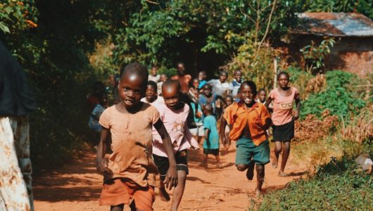 Photograph of smiling African children running